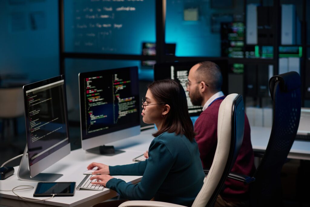 IT professionals managing code and security systems in a server room, representing DIY healthcare cloud management for in-house compliance and data protection.